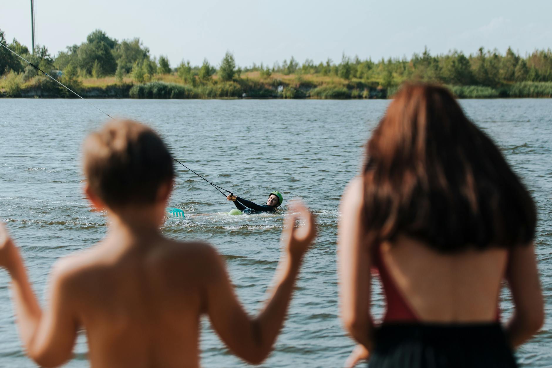 Family kayaking together on calm lake waters surrounded by mountains