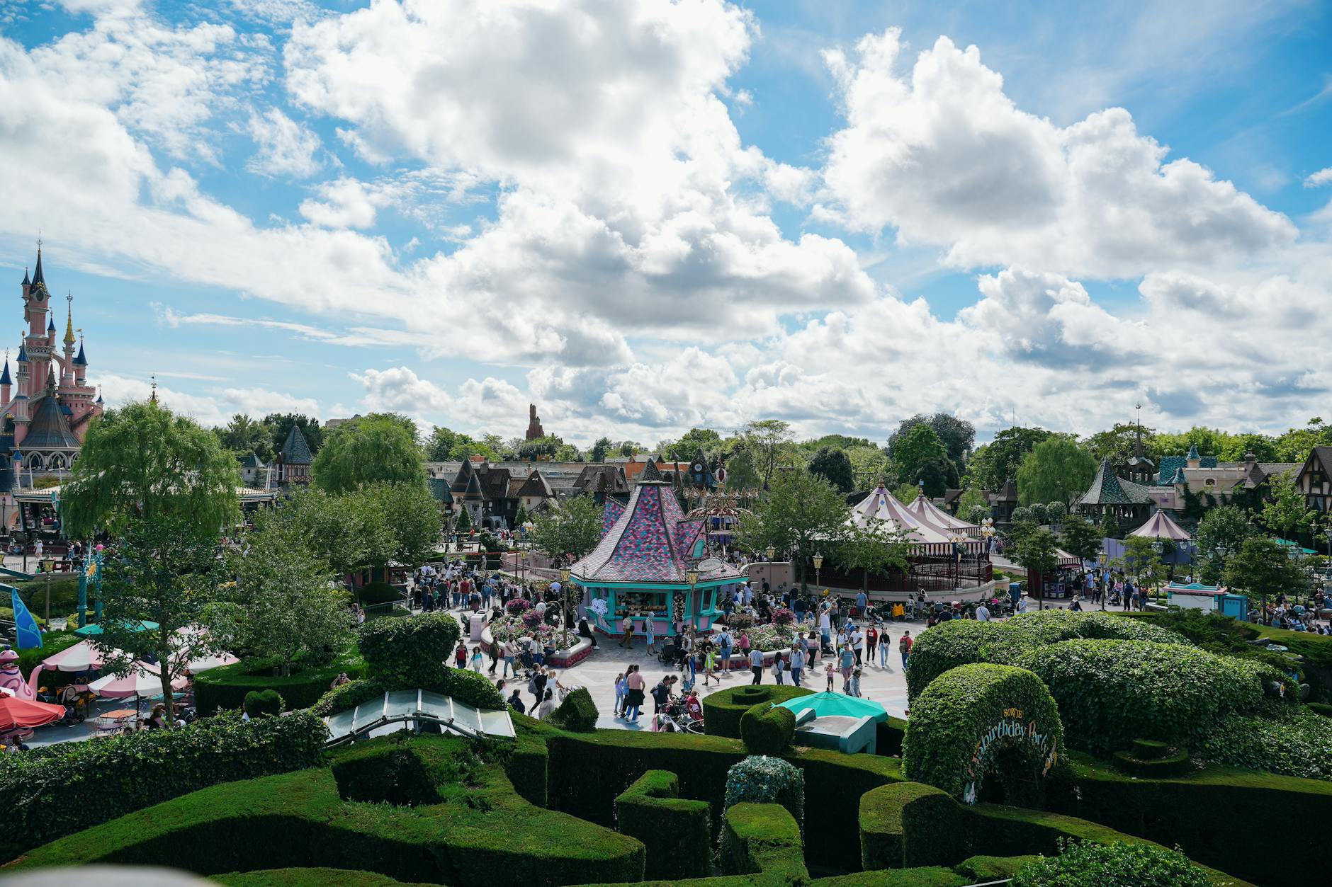 Disneyland Paris castle rising above visitors walking along the park's main pathway