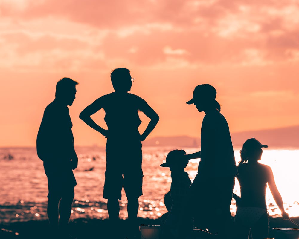 Family silhouette enjoying sunset on Hawaiian beach