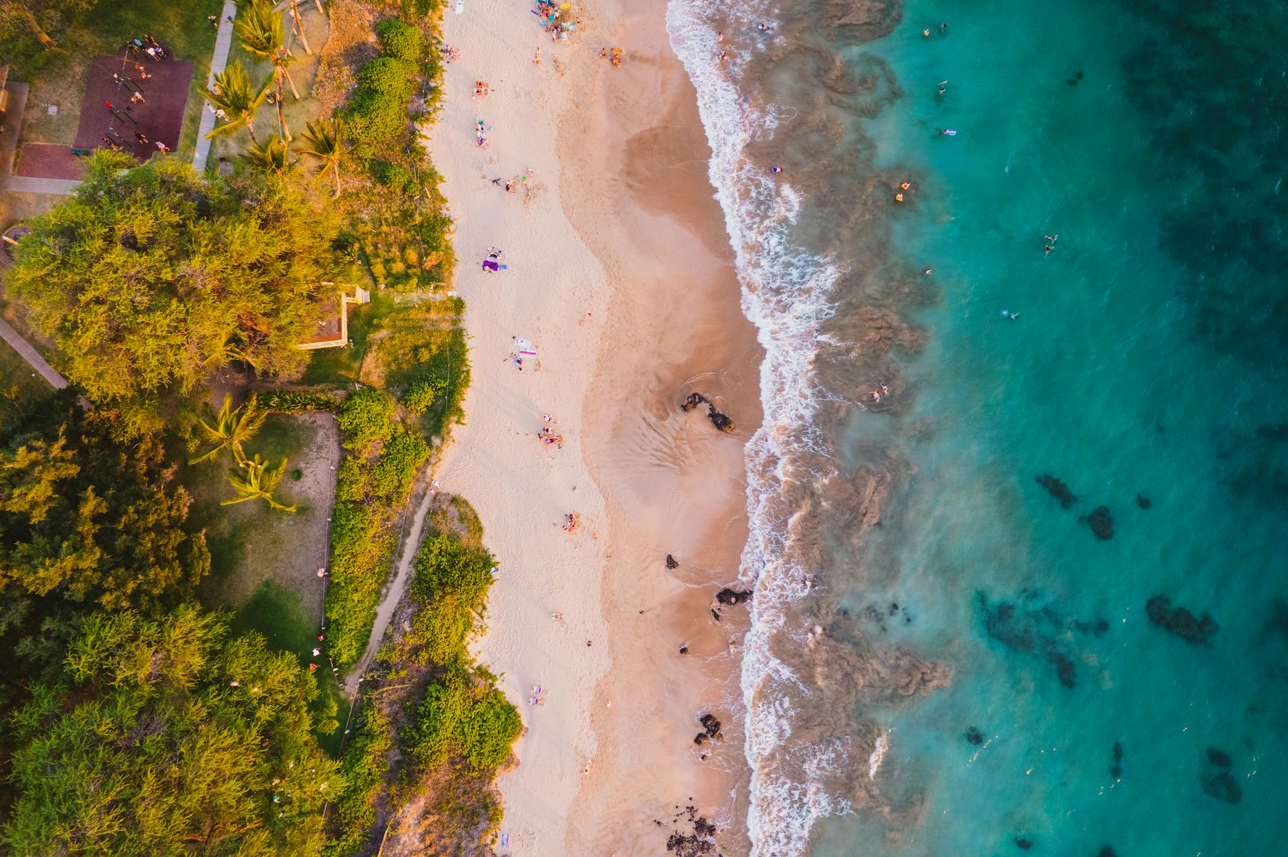 Aerial view of Maui coastline showing turquoise tropical waters and sandy beach