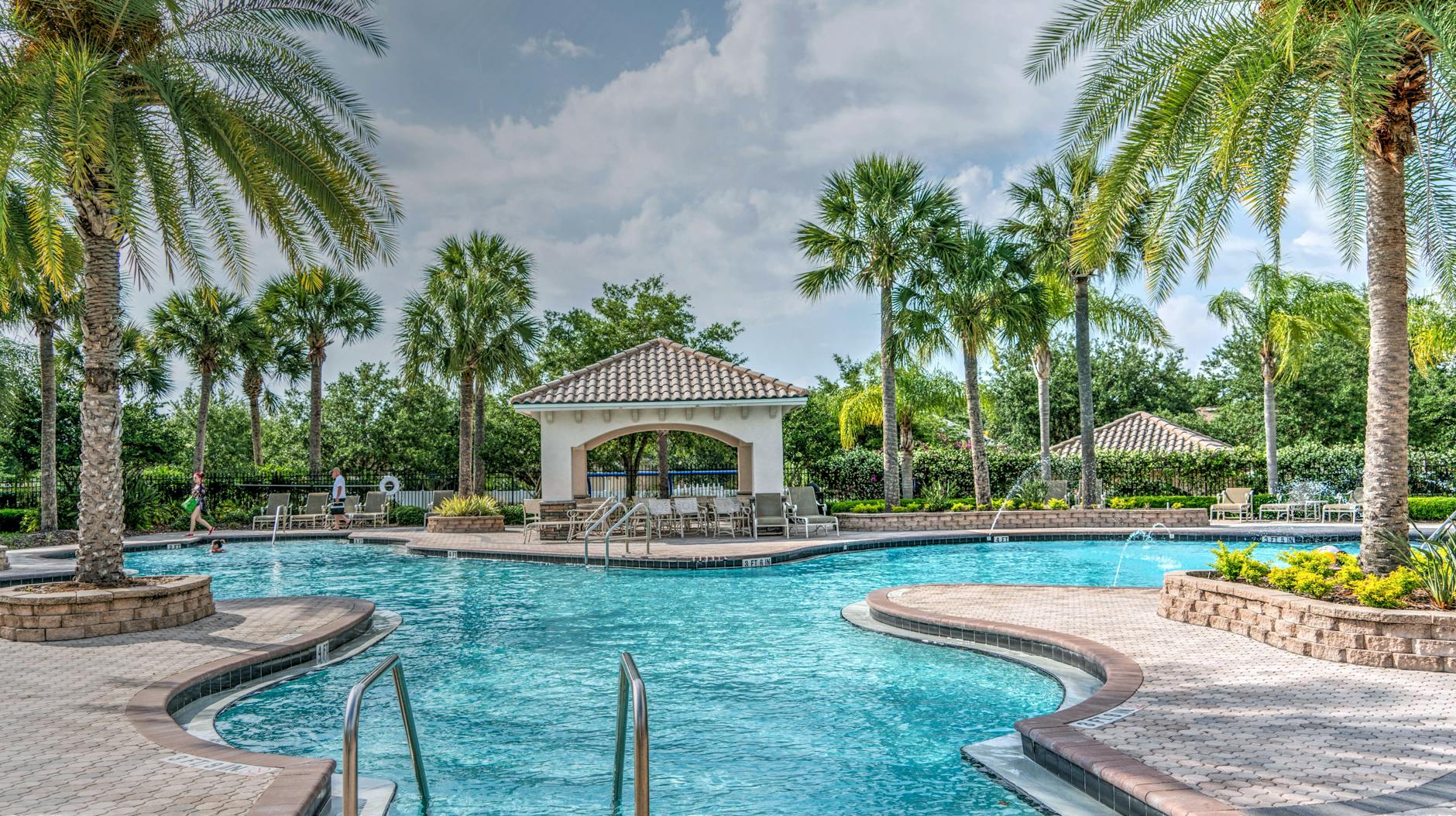 Tropical resort pool surrounded by palm trees perfect for an Orlando family hotel