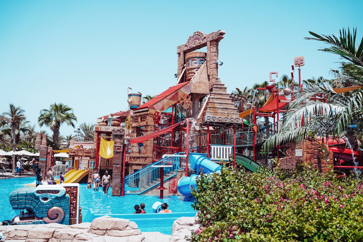 Families enjoying colorful waterslides and splash areas at a waterpark