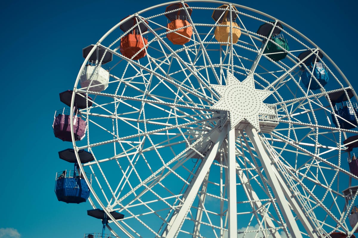 Colorful ferris wheel reaching into a clear blue sky at theme park