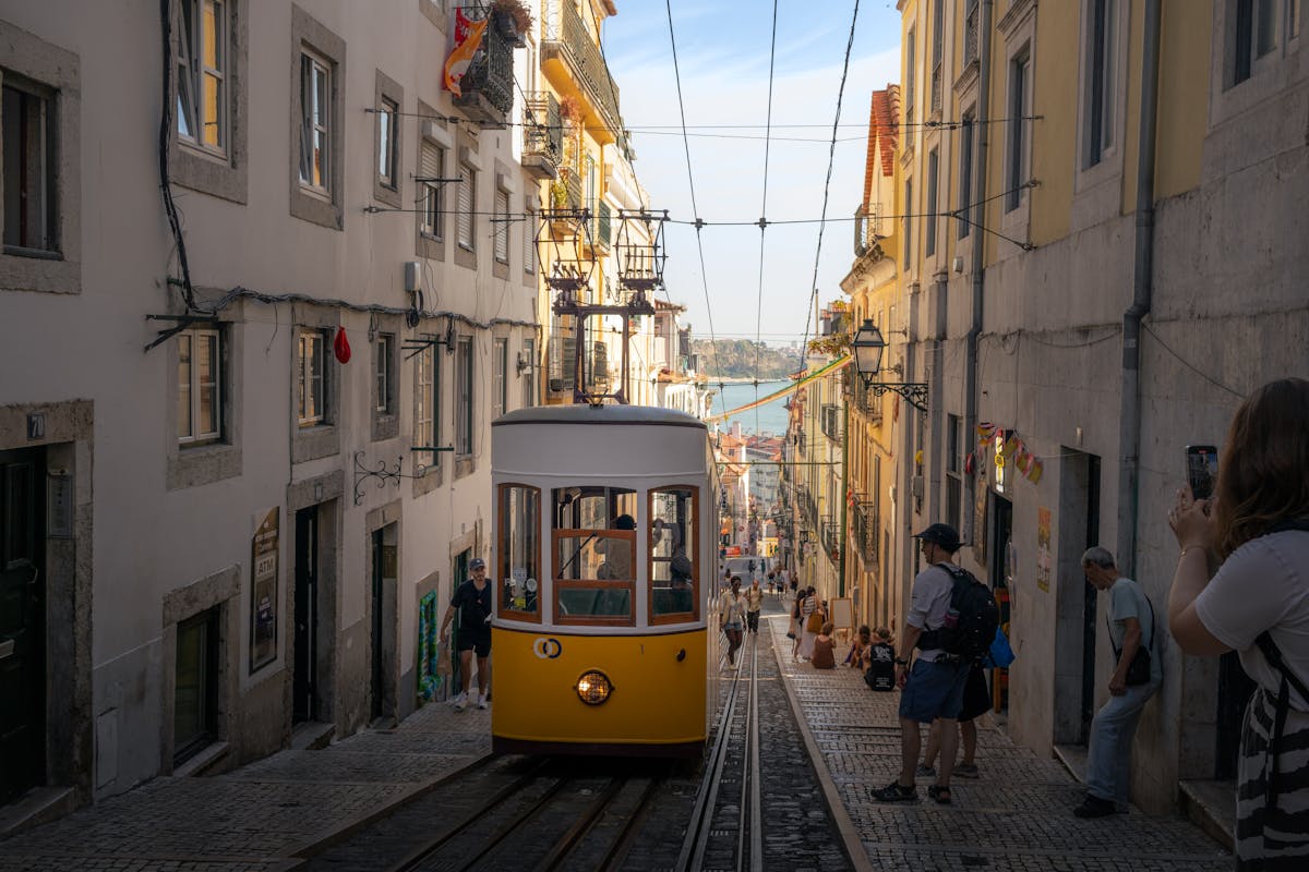 Yellow tram on a historic Lisbon street lined with old buildings in Portugal