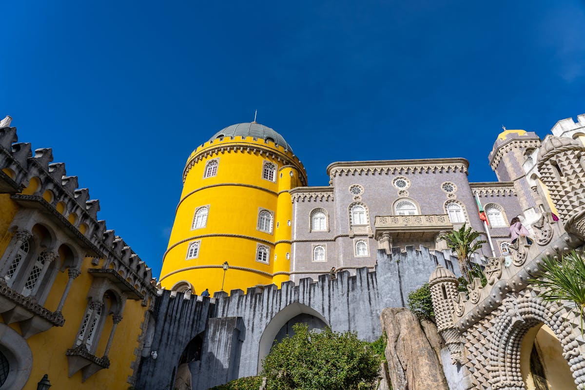 Colorful Pena Palace towers and walls in Sintra Portugal surrounded by trees