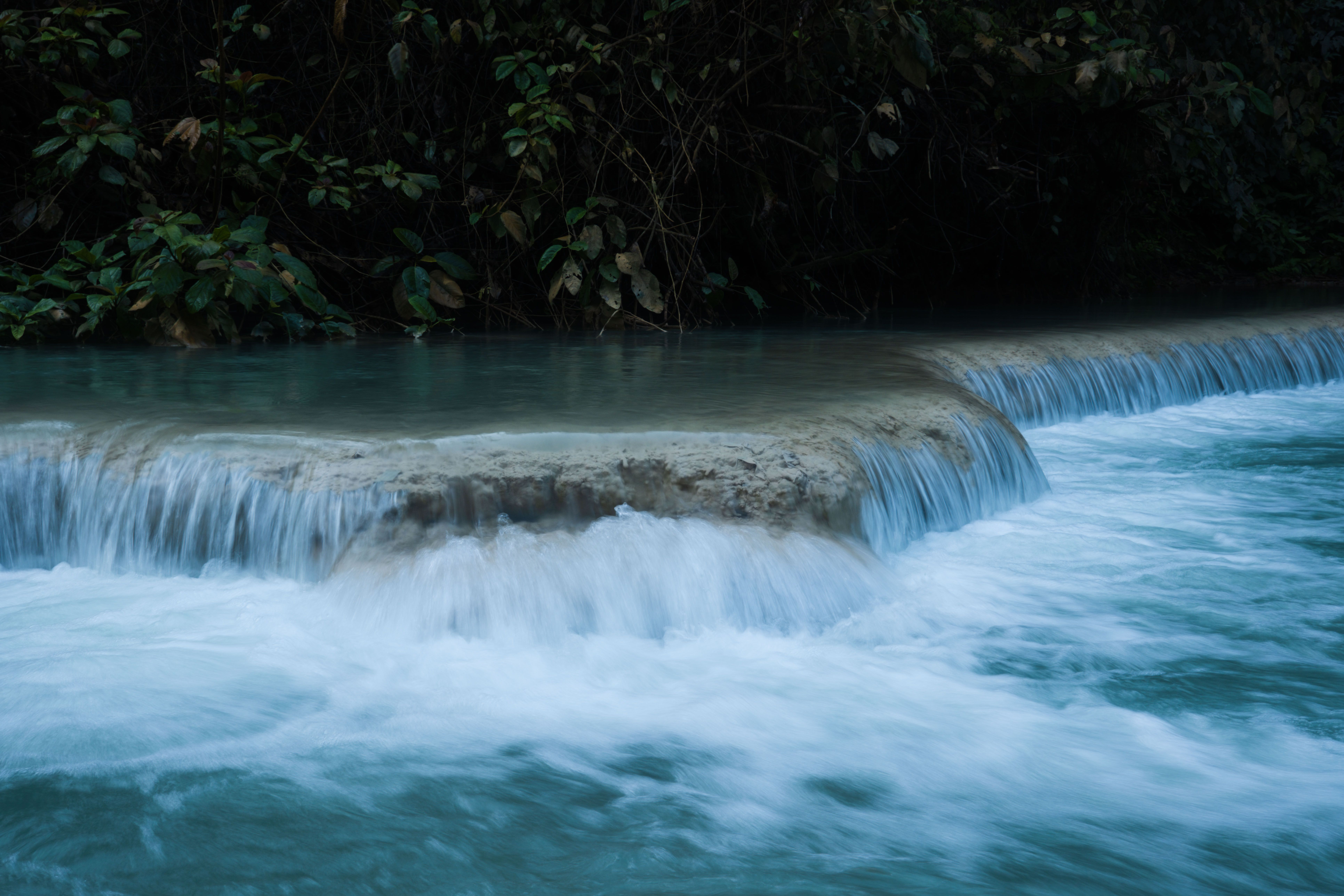 Tropical waterfall cascading through lush forest representing Jamaica's adventure-excursion differentiator including Dunn's River Falls and Blue Hole