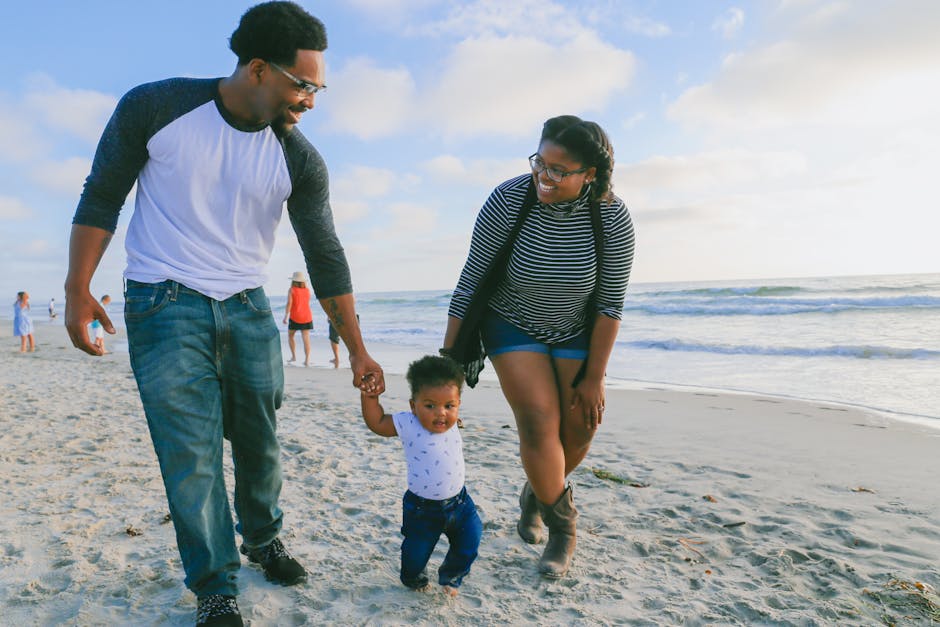 Family walking together along the shoreline at Del Mar Beach in California