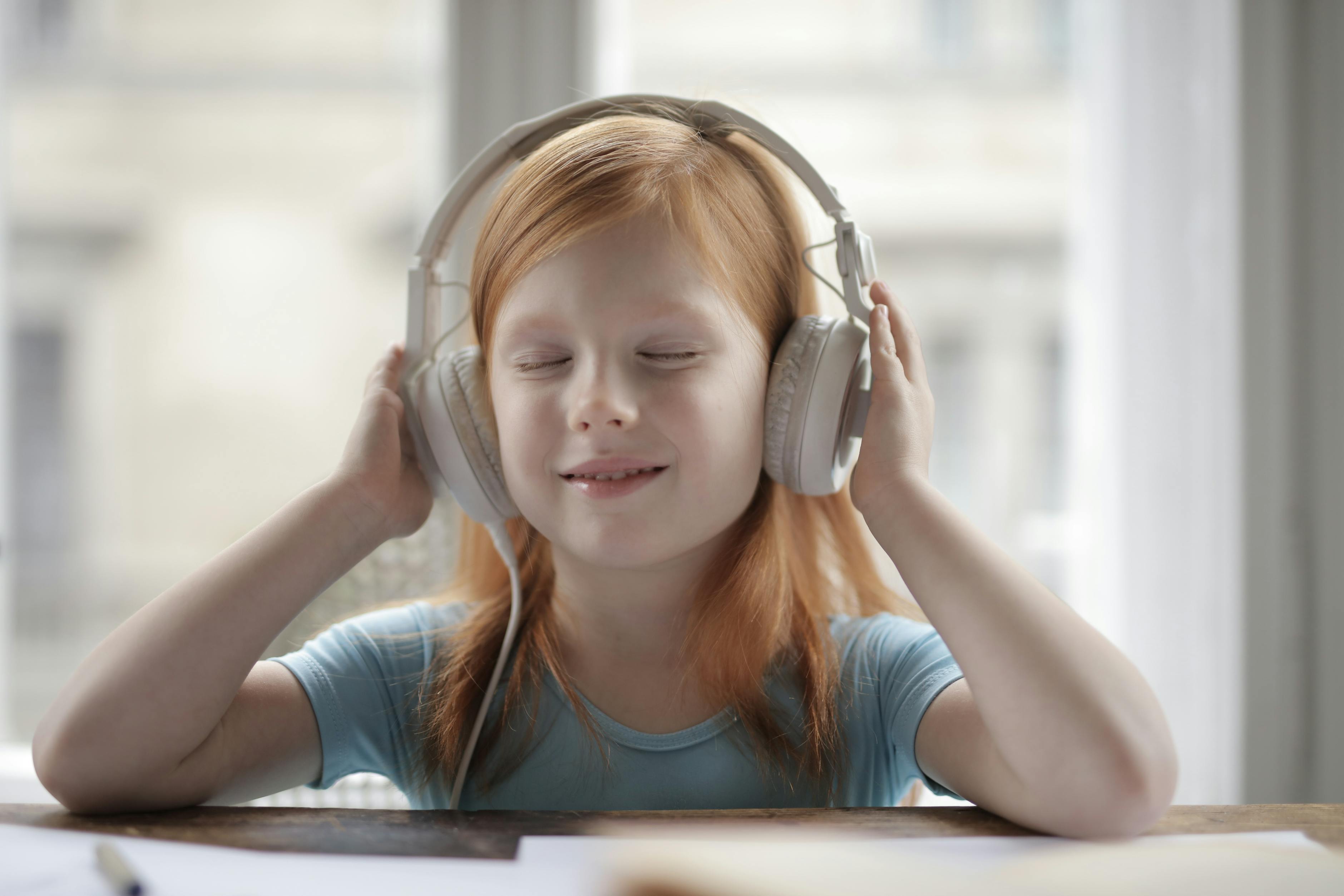 Smiling child wearing noise-cancelling headphones &mdash; the simple sensory-accommodation tool that makes theme park visits possible for many families