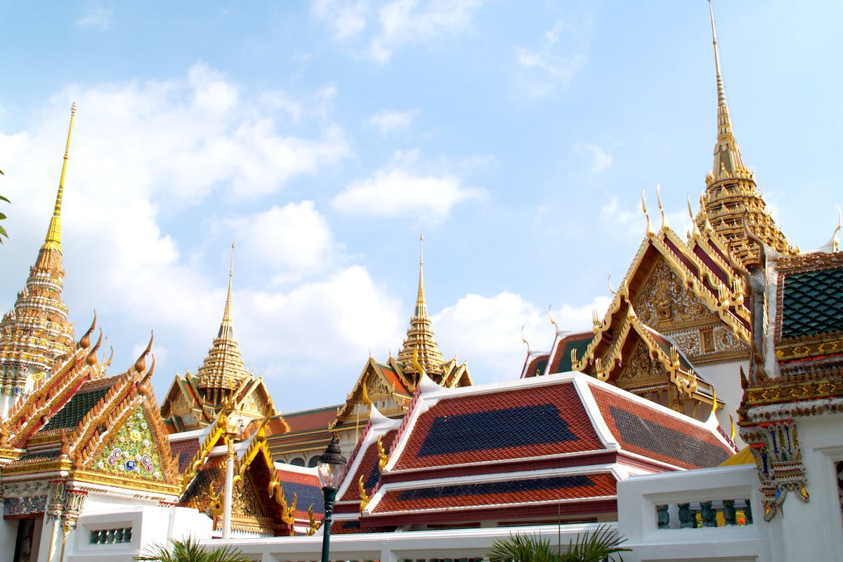 Colourful Bangkok temple with ornate golden spires and red roof details