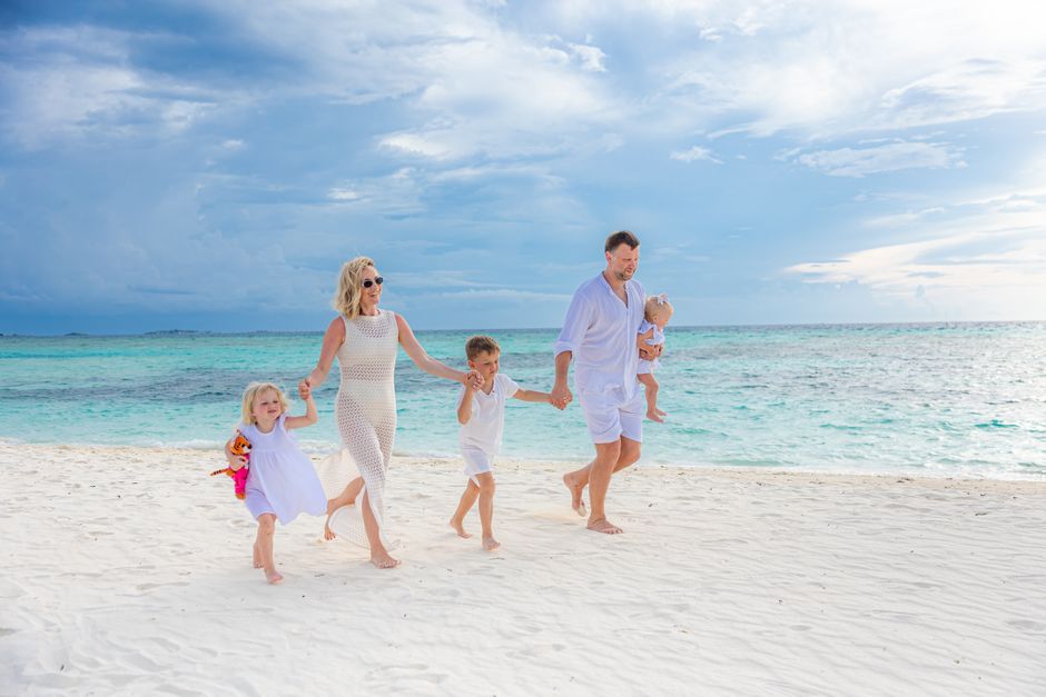 Family walking along a calm turquoise St Thomas beach, the kind of shallow shoreline that suits younger kids