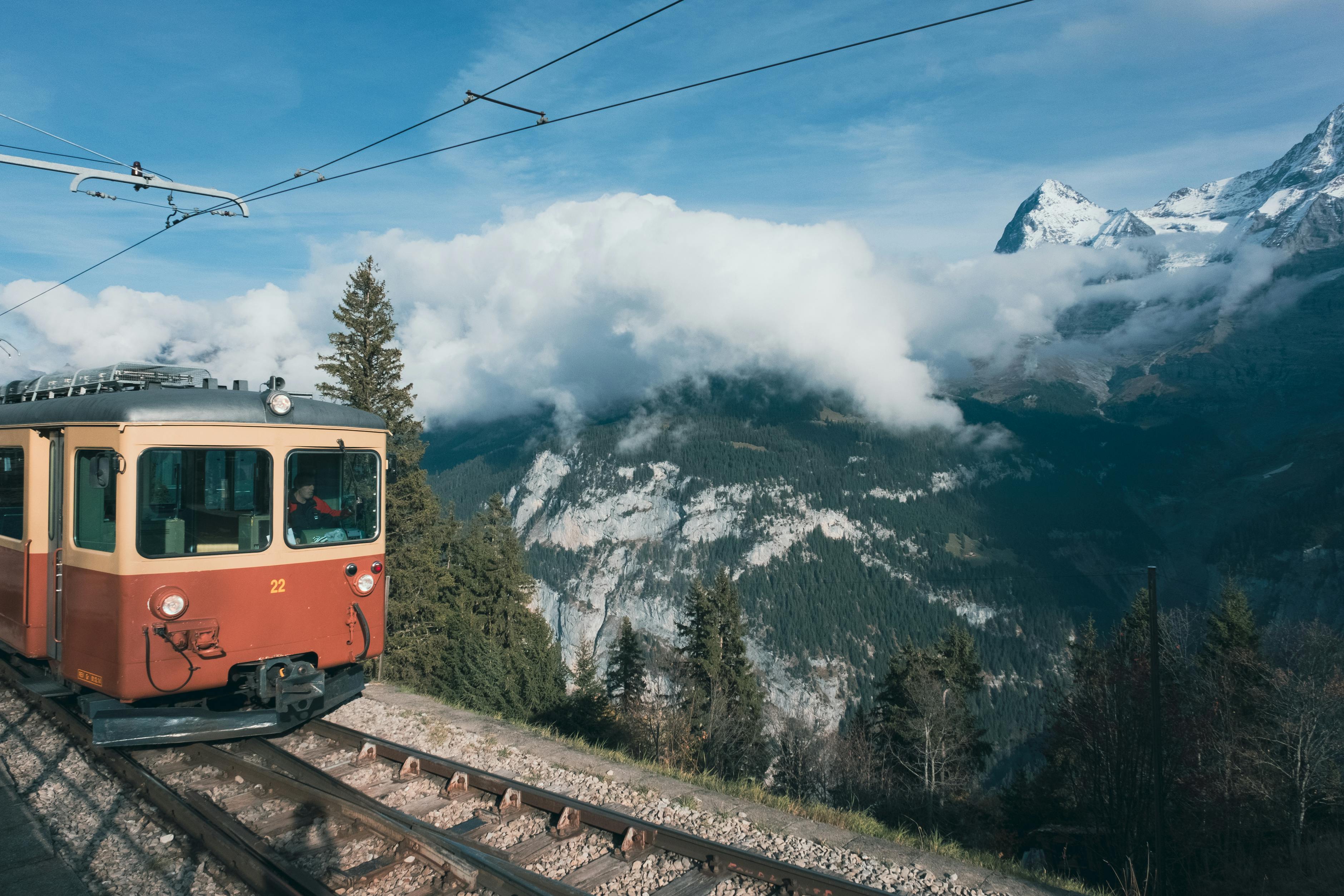 A Swiss train winds through alpine scenery &mdash; the rail backbone that makes the Swiss Travel Pass and a multi-base family itinerary work