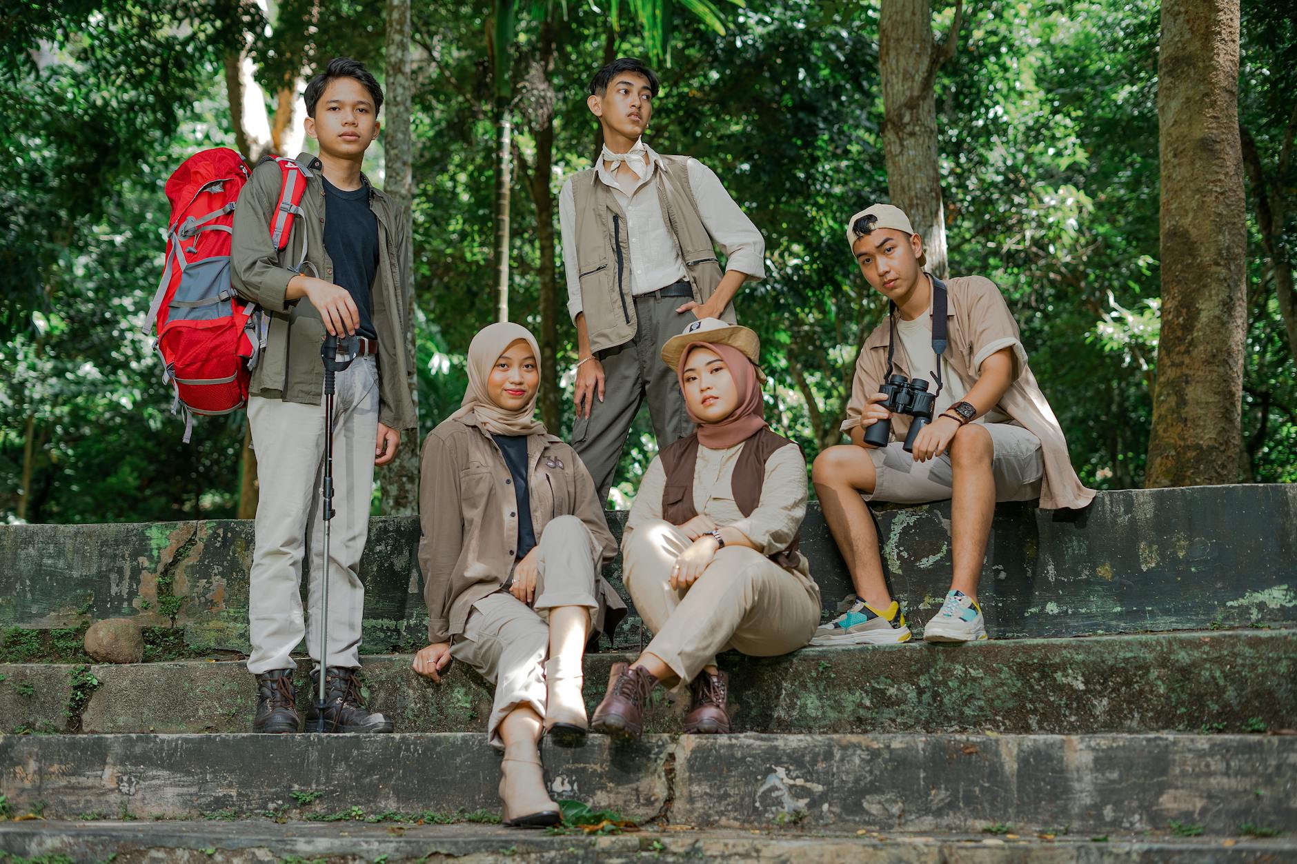 Group of teenagers hiking through a lush jungle trail with backpacks