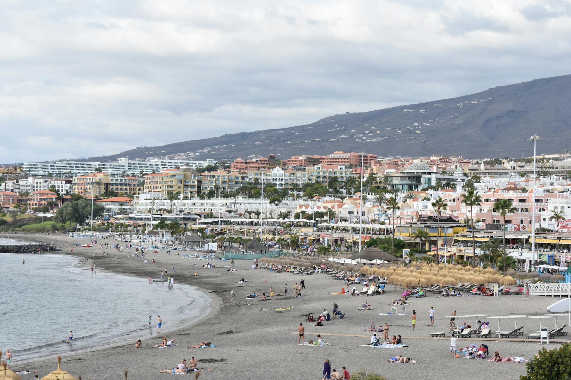 Beachgoers enjoying a sunny day on a Canary Islands coastal beach
