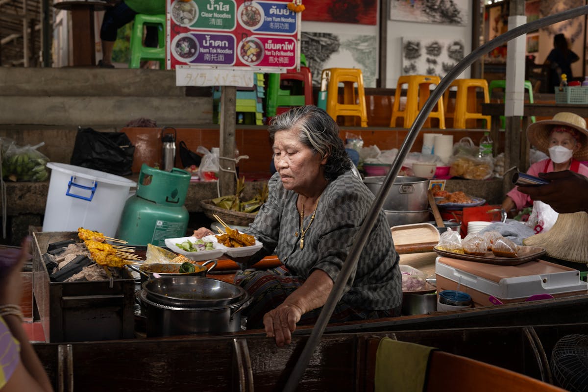 Authentic Thai street food vendor preparing dishes at a Bangkok market