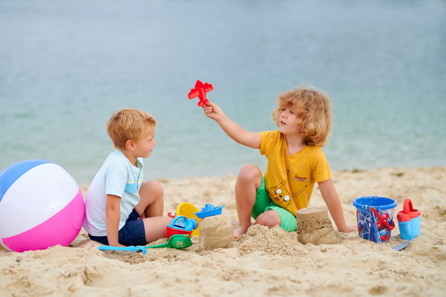 Kids building sandcastles and playing on a sunny beach family vacation