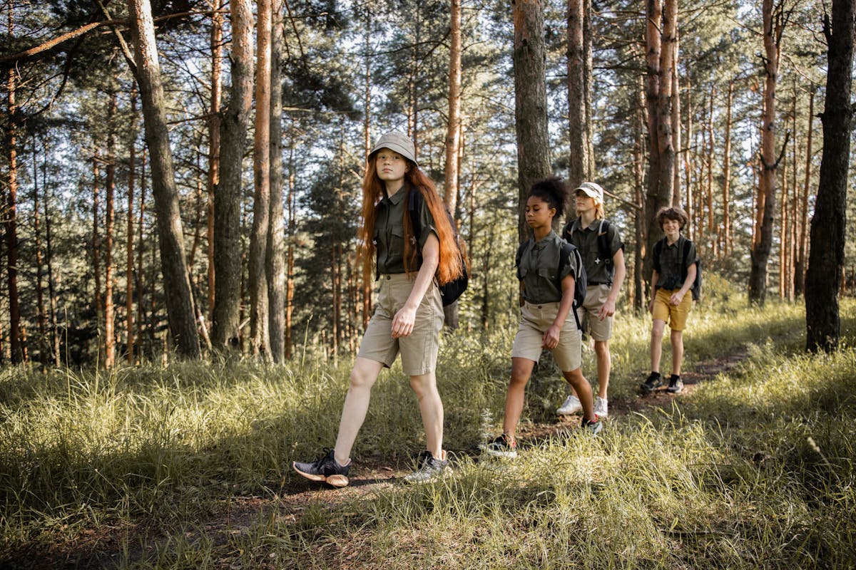 Teenagers hiking together through a forest trail on an adventure