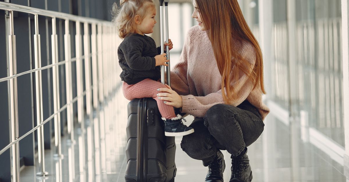 Mother and daughter at airport with suitcase