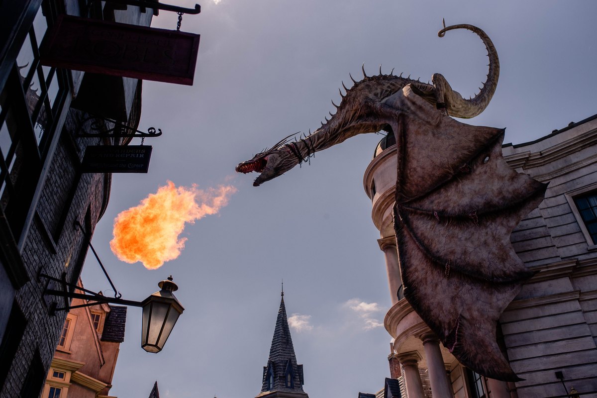 Fire-breathing dragon sculpture over a themed street in Orlando, the dragon spectacle Epic Universe's Isle of Berk trades on