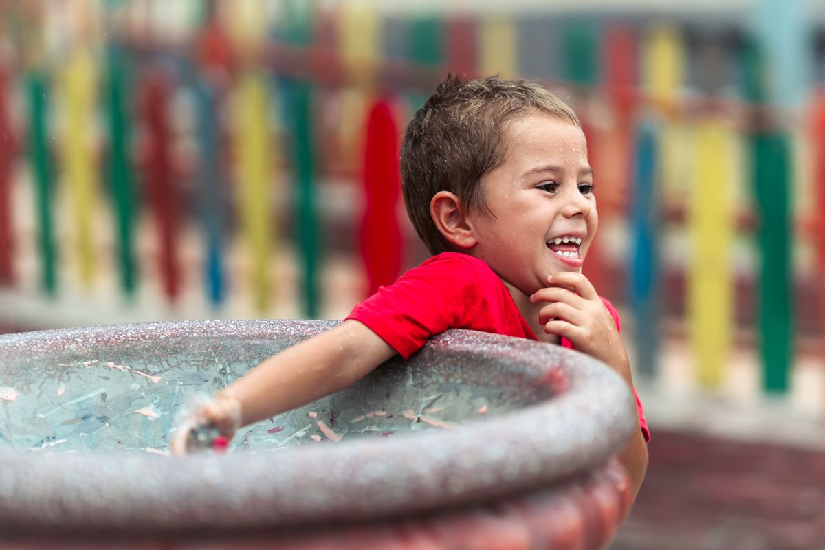 Young child cooling off at a splash pad water play area like those throughout Universal Kids Resort