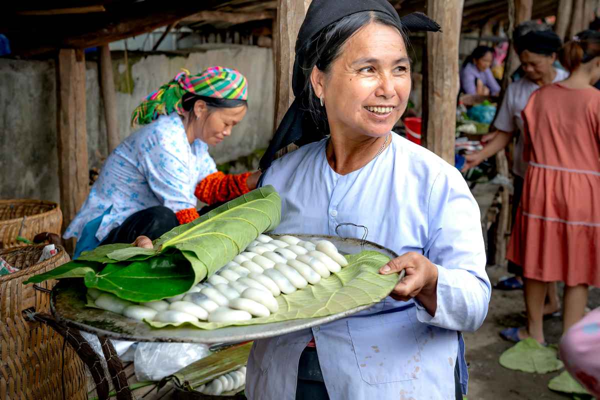 Vietnamese local market with fresh produce and vendors, showing affordable food options for budget family travel