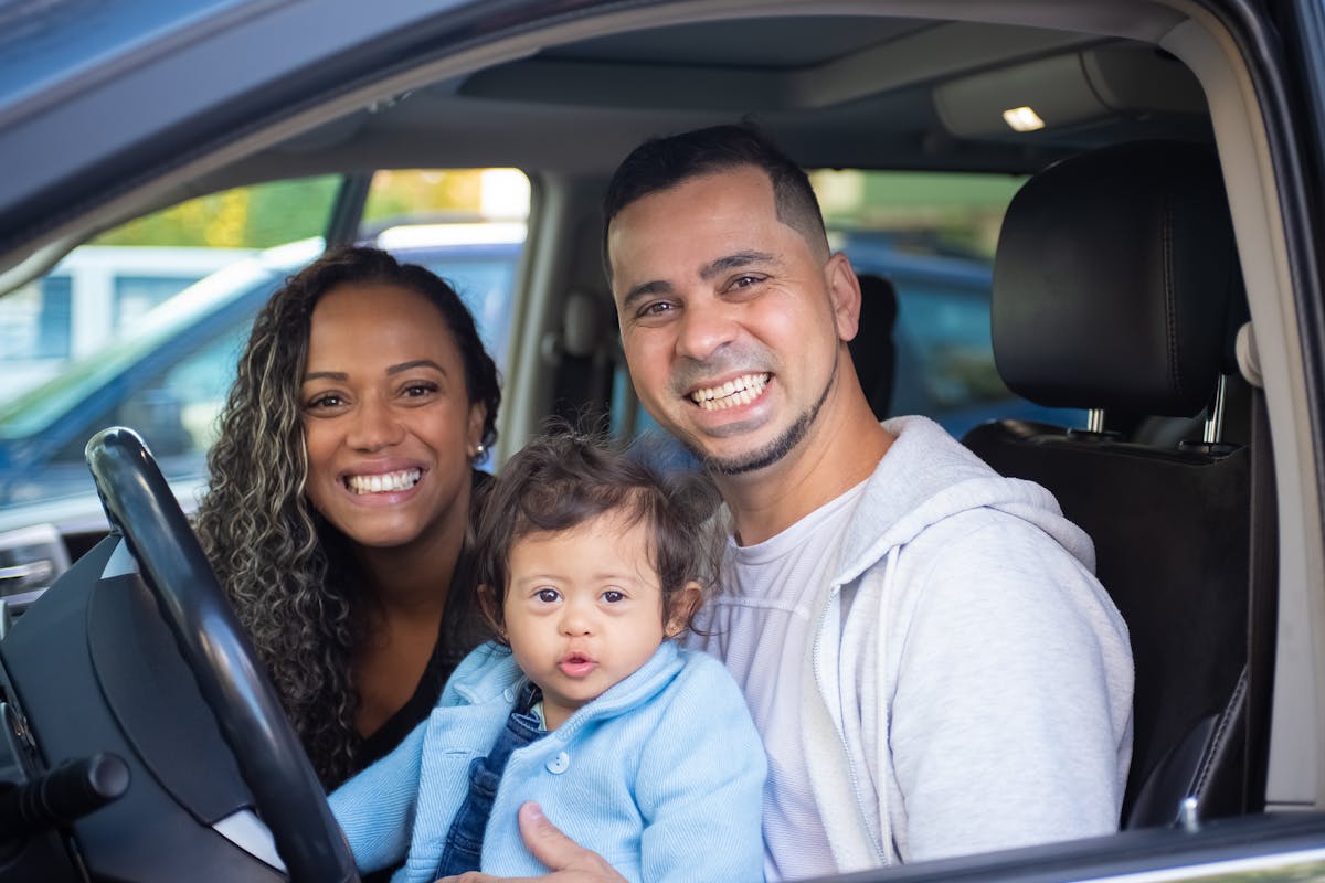 Family with child in a car preparing for a trip