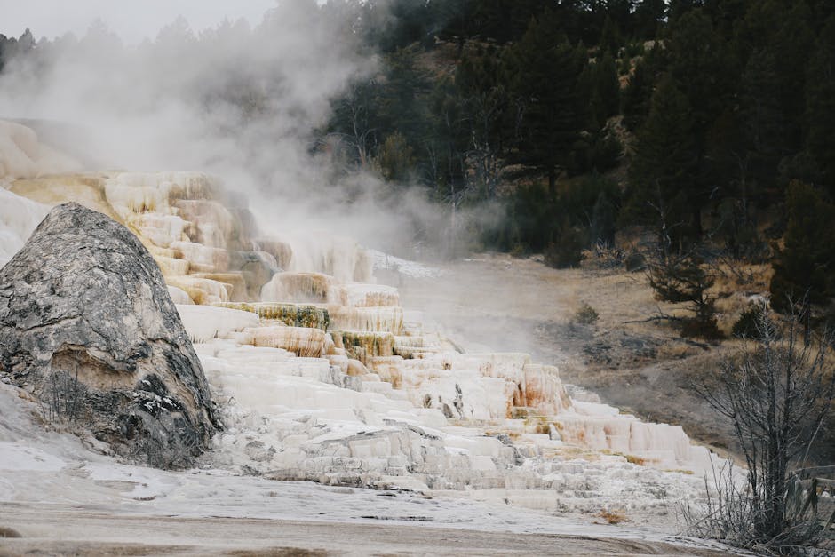 Mammoth Hot Springs terraces in Yellowstone with steam rising from mineral formations