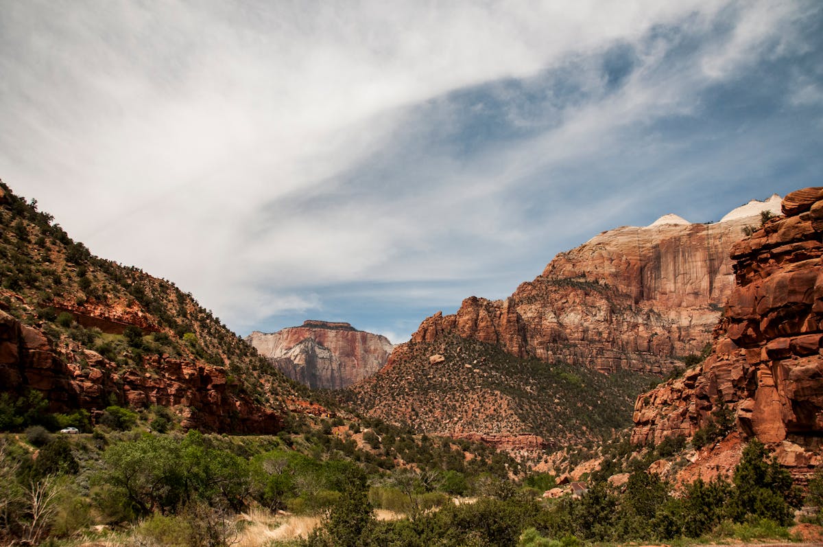 Towering sandstone cliffs and red rock formations at Zion National Park under a bright Utah sky